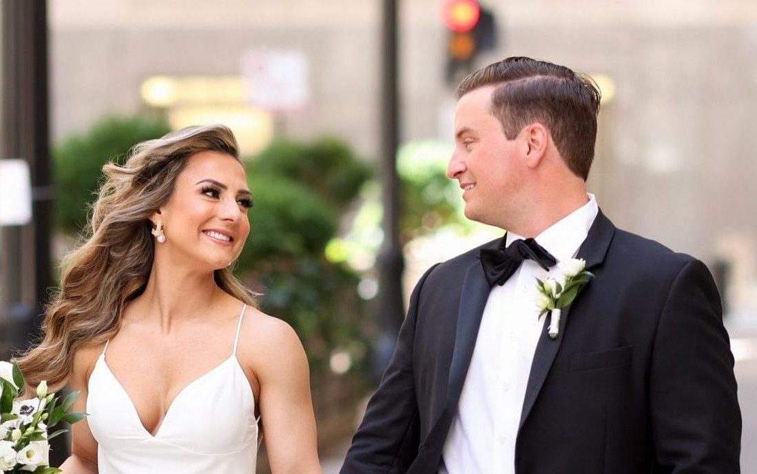 Bride and groom holding hands while walking and looking at each other